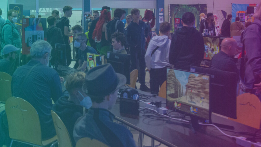 In der Gaming Area spielen viele Menschen an Konsolen.